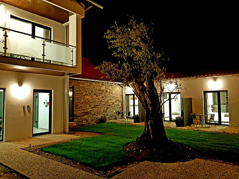 Jardim e fachada do hotel ao anoitecer